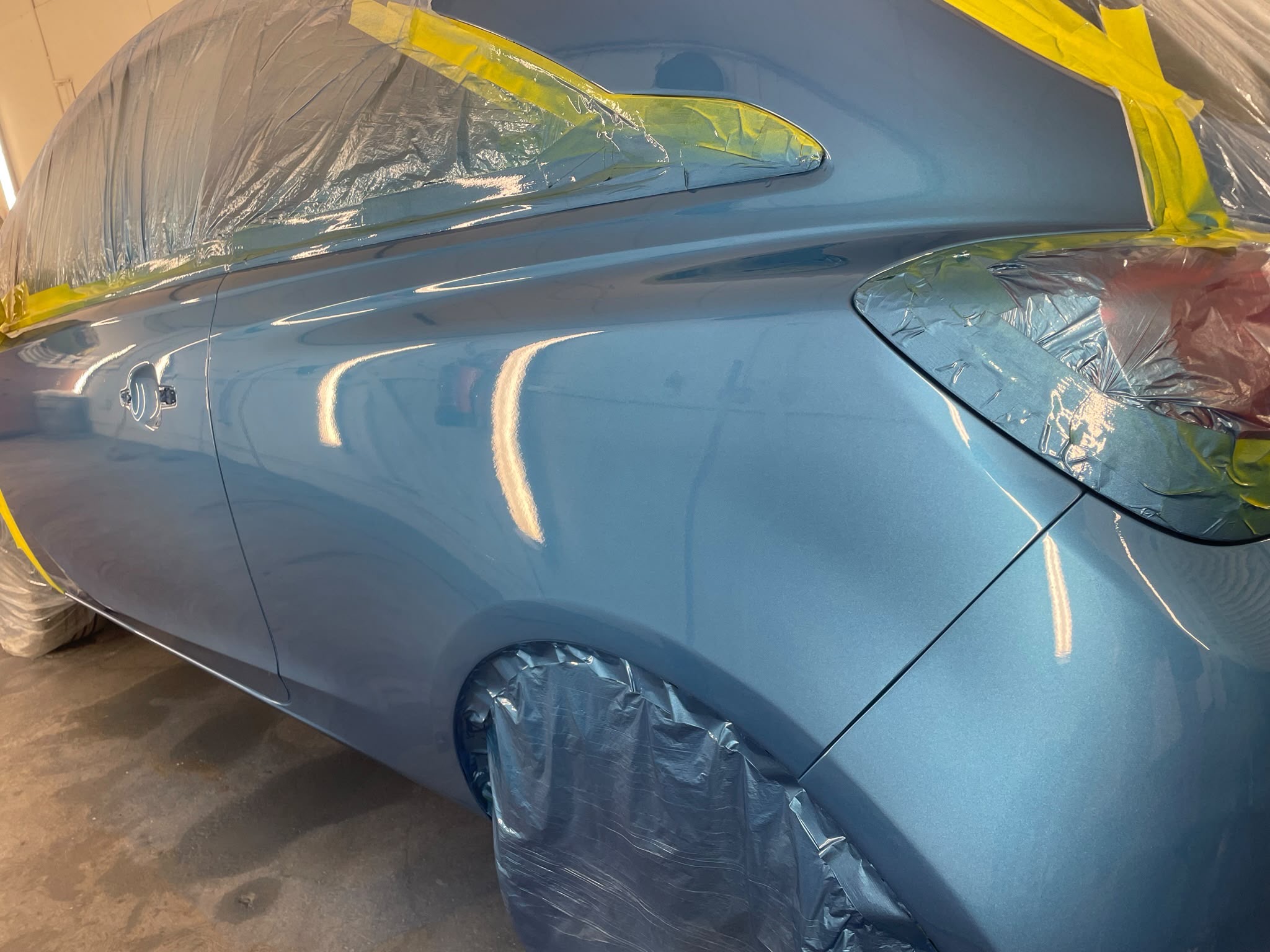 Metallic blue car side panel refinished