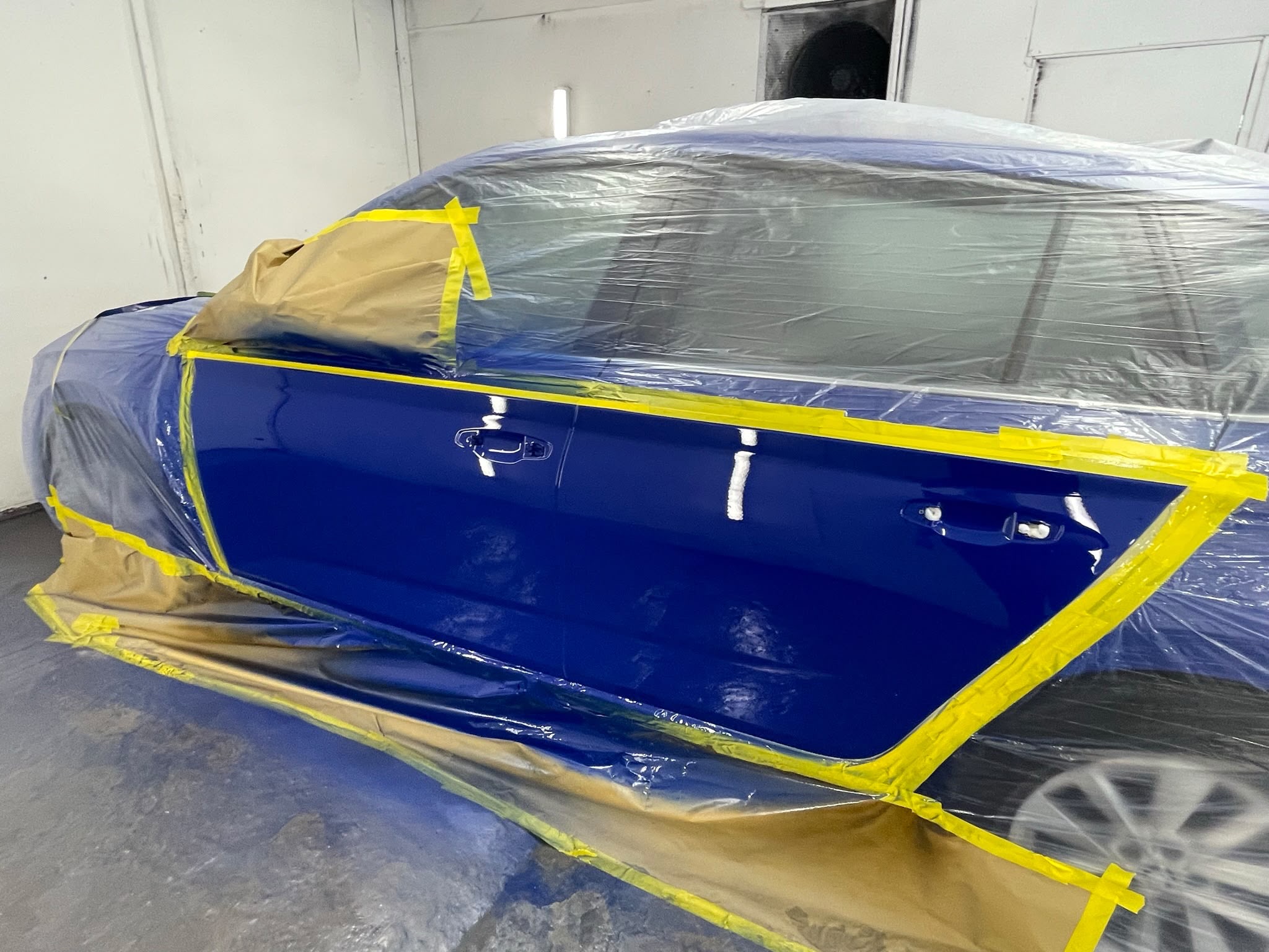 Deep blue door freshly painted in the booth