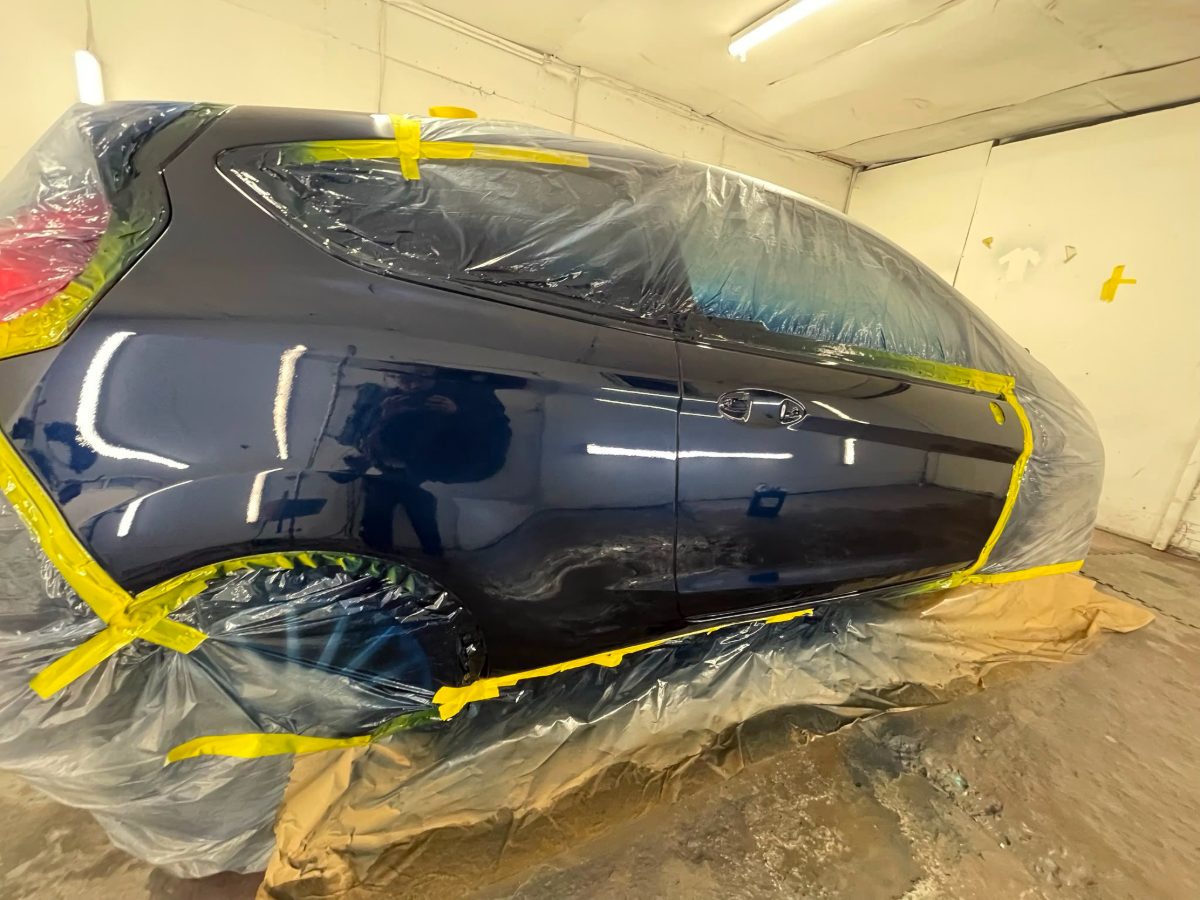 The same car with the panel repaired and refinished to a mirror shine
